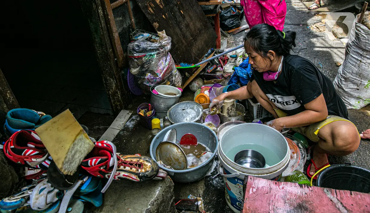 Warga membersihkan perabotan usai terendam banjir di permukiman kawasan Kampung Melayu, Jakarta, Selasa (9/2/2021). Banjir yang berangsur surut dimanfaatkan warga untuk membersihkan rumah dan barang-barang dari endapan lumpur. (Liputan6.com/Faizal Fanani)