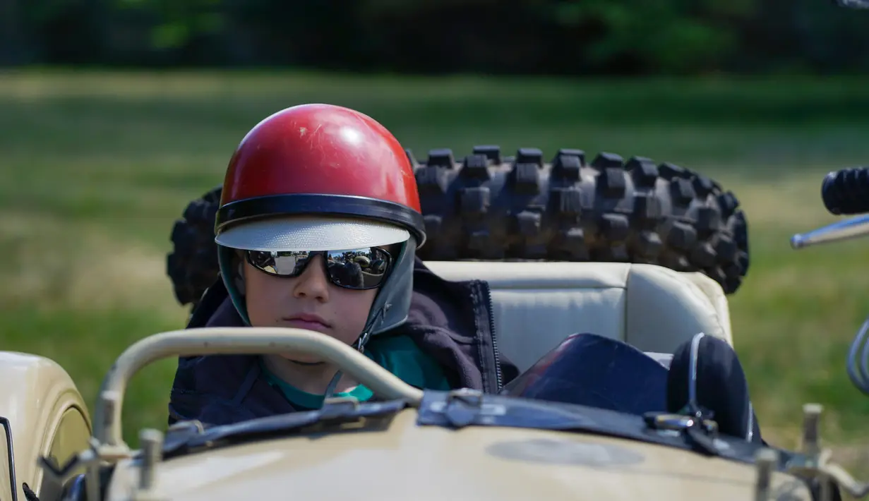 Seorang anak laki-laki duduk di sespan sepeda motor antik dalam sebuah festival yang diadakan di Karosta di Kota Liepaja, Latvia, pada 14 Juni 2020. (Xinhua/Janis Laizans)