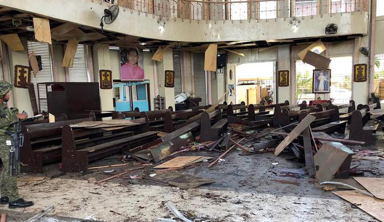 Tentara Filipina berjaga di dalam gereja pasca ledakan bom di Gereja Katolik Jolo, Filipina Selatan, Minggu (27/1). Dua bom meledak, Sedikitnya 27 orang tewas dan 57 orang lainnya mengalami luka. (Angkatan Bersenjata Filipina/HO/AFP)