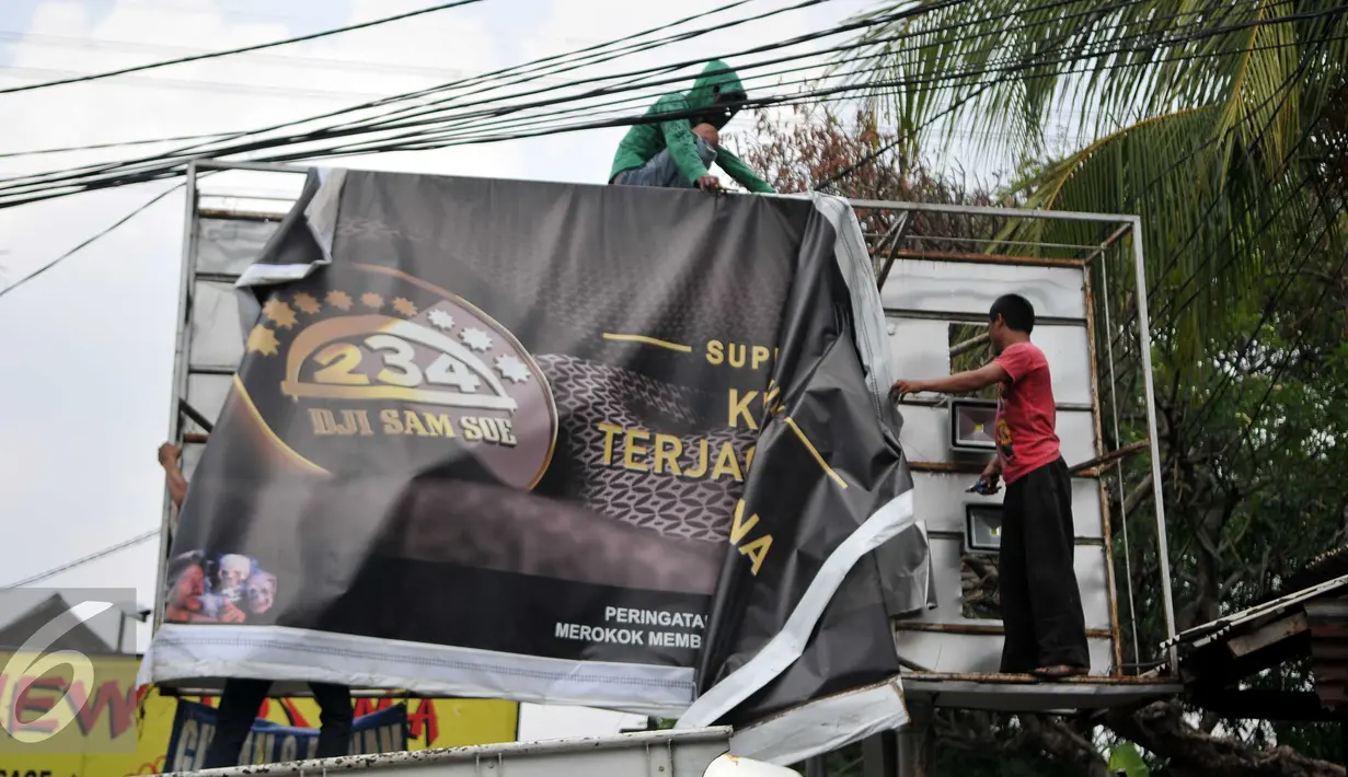 Warga dan petugas Satpol PP menurunkan papan reklame rokok, Jakarta, Rabu (18/11). Gubernur DKI Jakarta menerbitkan Peraturan Gubernur Nomor 1 Tahun 2015 tentang Larangan Penyelenggaraan Reklame Rokok pada Media Luar Ruang. (Liputan6.com/Gempur M Surya)