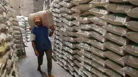 Pekerja memanggul beras di sebuah industri pengolahan beras di Kediri, Jawa Timur. Kemarau panjang membuat musim tanam padi mundur.(Antara)