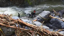 Hingga Senin (1/12/2025), tim gabungan terus melakukan upaya pencarian dan penyelamatan korban banjir yang melanda sejumlah wilayah di Aceh, Sumatera Utara, dan Sumatera Barat. Tampak dalam foto, tim penyelamat mencari korban banjir di Tanah Datar, Sumatera Barat, Senin 1 Desember 2025. (AP Photo/Nazar Chaniago)