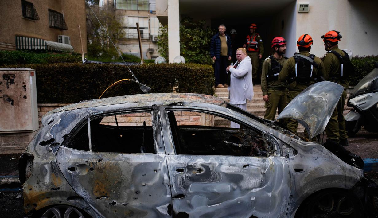 Situasi ini memicu kekhawatiran konflik skala penuh yang melibatkan negara-negara lain di kawasan Timur Tengah. Tampak dalam foto, warga dan pasukan keamanan Israel memeriksa lokasi yang terkena serangan rudal Iran di Petah Tikva, Israel, Selasa 31 Maret 2026. (AP Photo/Ohad Zwigenberg)