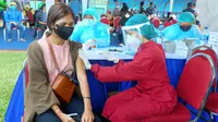Vaksinator menyuntikkan vaksin Covid-19 ke seorang peserta vaksinasi massal di Stadion Gajayana, Kota Malang pada Sabtu, 7 Agustus 2021 (Liputan6.com/Zainul Arifin)