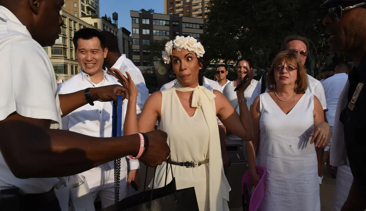 Para tamu menjalani pemeriksaan sebelum menghadiri Diner en blanc (Dinner in White) di alun-alun Lincoln Center, New York, Selasa (22/8). Pada saat acara rahasia ini partisipan membawa sendiri makanan serta kursi dan meja mereka. (TIMOTHY A. CLARY/AFP)