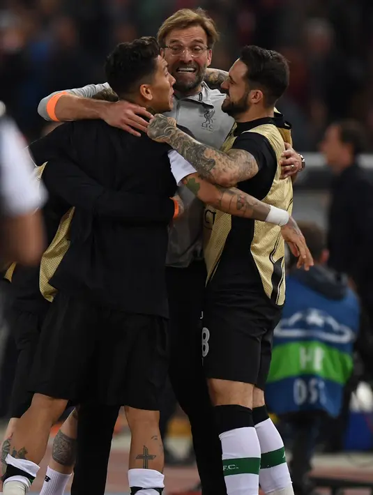 Pelatih Jurgen Klopp memeluk Roberto Firmino dan Danny Ings usai pertandingan semifinal Liga Champions di Stadion Olimpiade, Roma (2/5). Liverpool takluk 4-2 atas Roma di leg kedua dan melaju ke final usai menang agregat 7-6. (AFP Photo/Paul Ellis)