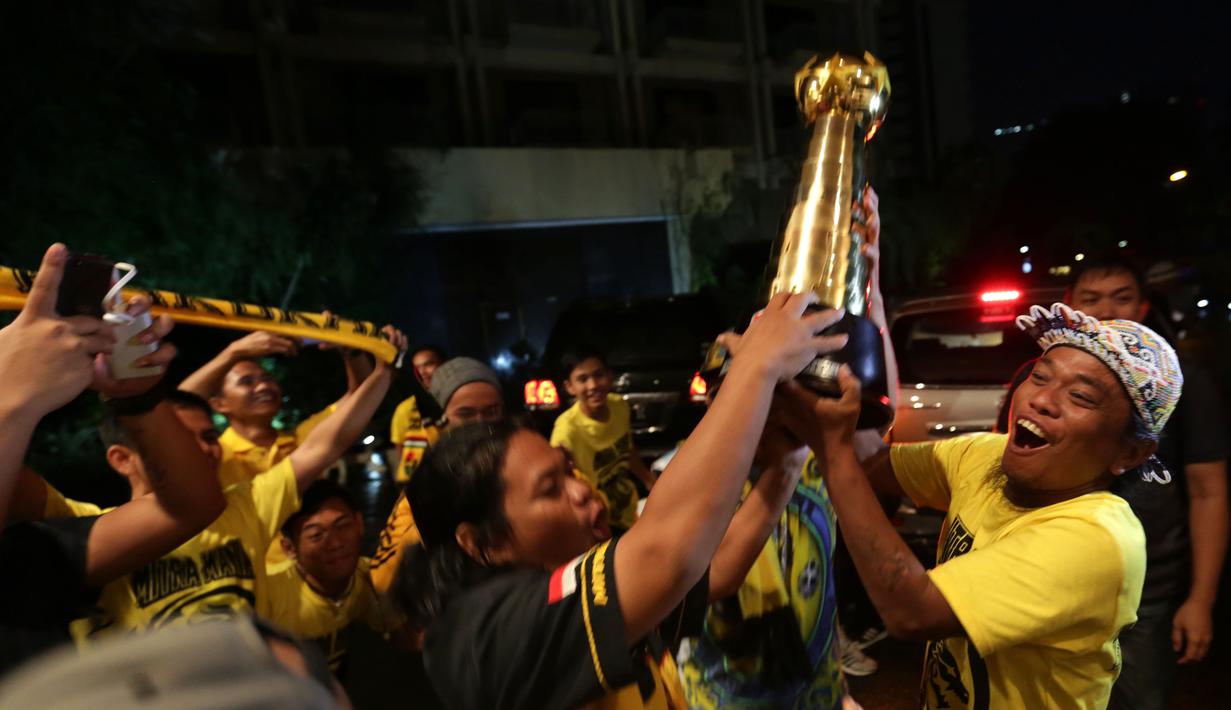 Suporter Mitra Kukar merayakan gelar juara dengan trofi Piala Jenderal Sudirman di Hotel Sultan, Jakarta, Minggu (24/1/2016). (Bola.com/Arief Bagus)