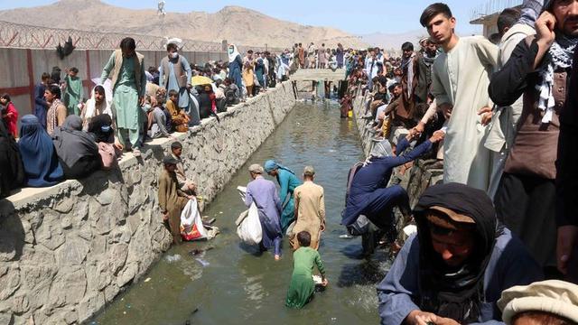 Orang-orang menunggu di luar bandara karena tidak bisa masuk