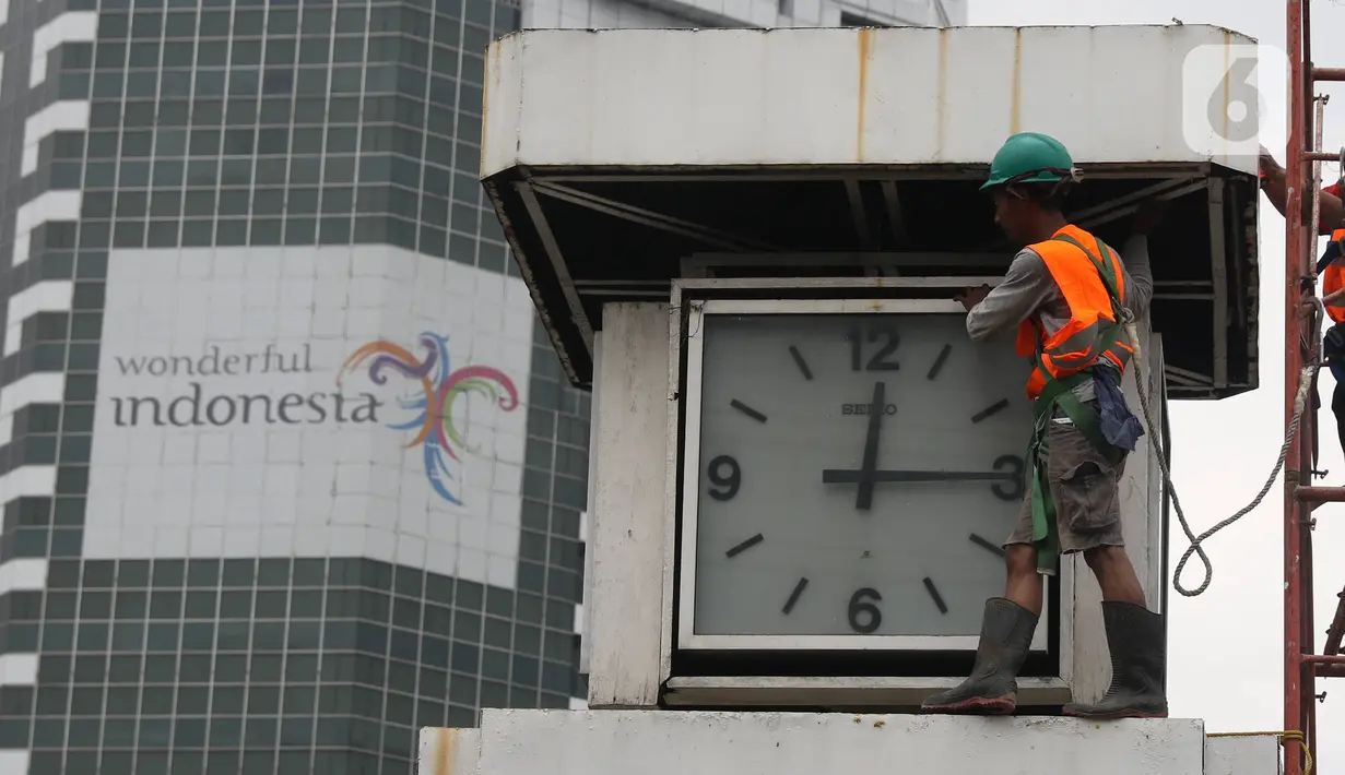 Petugas melakukan perawatan tugu jam yang berada di Merdeka Selatan, Jakarta, Minggu (2/2/2020). Perawatan tersebut dilakukan untuk pengecekan kondisi jam yang nantinya akan dipasangkan panel surya sebagai daya power agar tugu jam dapat berfungsi sebagai petunjuk waktu. (Liputan6.com/Angga Yuniar)