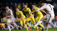 Striker Real Madrid Cristiano Ronaldo mengeksekusi penalti ke gawang Villarreal pada laga La Liga di El Madrigal, Villarreal, Minggu (26/2/2017). (AFP/Biel Alino)