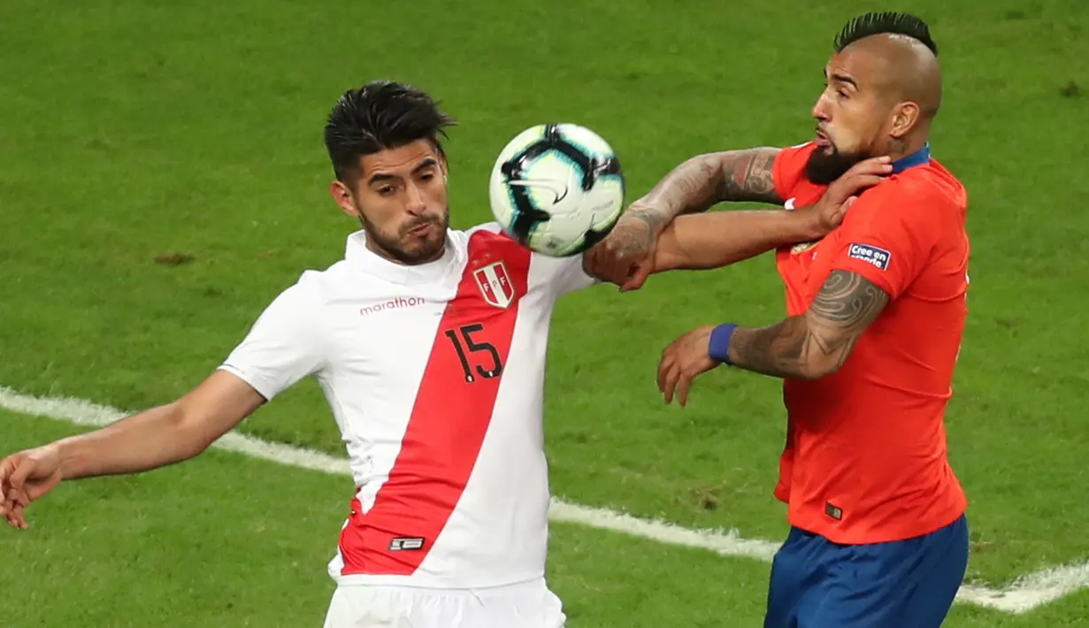 Pemain timnas Peru, Carlos Zambrano  berebut bola dengan gelandang timnas Cile, Arturo Vidal pada semifinal Copa America 2019 di Arena do Gremio, Kamis (4/7/2019) pagi. Peru lolos ke final Copa America 2019 setelah mengalahkan juara bertahan, Cile, dengan skor 3-0. (AP/ Edison Vara)