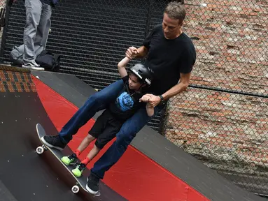 Legenda skateboard Tony Hawk bersama seorang anak Connor Curis meluncur dengan papan skateboard di Downtown Detroit (15/8). Taman skateboard ini  oleh Tony Hawk dan Ryan McGinness. (Tanya Moutzalias/Ann Arbor News-MLive.com Detroit via AP)