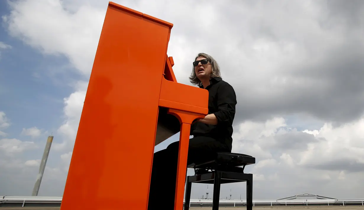 Musisi asal Jerman, Stefan Aaron menggelar `Orange Piano Tour` di Jepang, Jumat (4/9/2015). Stefan tampak bergaya dengan Piano orangenya. (REUTERS/Yuya Shino)