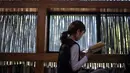 Foto yang diambil pada 15 September 2018 memperlihatkan seorang wanita membaca buku di Perpustakaan Liyuan, pinggiran kota Beijing. Seluruh dinding perpustakaan dihias dengan menggunakan ranting-ranting kering. (FRED DUFOUR/AFP)