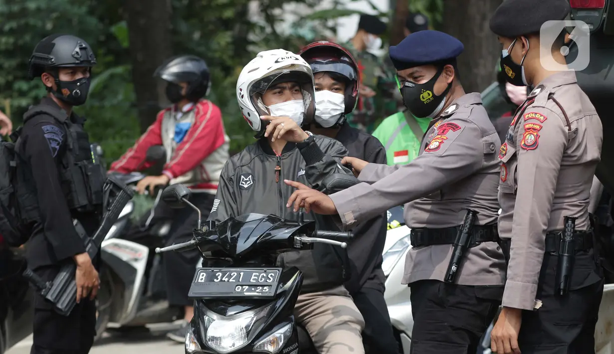 Petugas dari Korps Brimob memeriksa surat keterangan warga saat penyekatan di Jalan Lenteng Agung Raya, Jakarta, Selasa (6/7/2021). Petugas hanya mengizinkan warga yang memiliki kepentingan esensial atau mendesak bisa melintas jalan Lenteng Agung Raya. (Liputan6.com/Helmi Fithriansyah)