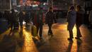 Pengunjung diterangi oleh pantulan sinar matahari saat mereka berjalan melalui pusat perbelanjaan pada hari terakhir minggu liburan Tahun Baru Imlek di Beijing, Jumat, 27 Januari 2023. (AP Photo/Mark Schiefelbein)