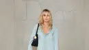 Miley Cyrus tampil kasual santai mengenakan denim on denim. Ia tampil dengan atasan kemeja lengan panjang dipadukan celana panjang denim. Sambil membawa tas hitam serasi dengan warna heelsnya.  [Dok. DIOR]
