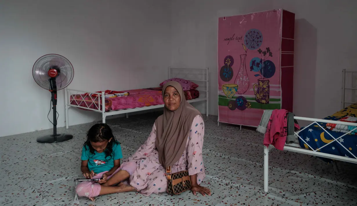 Penyerahan huntara merupakan bagian dari komitmen Danantara Indonesia untuk menghadirkan hunian sementara yang layak, aman, dan mendukung pemulihan layanan dasar bagi warga terdampak. Tampak dalam foto, warga duduk di dalam unit perumahan sementara yang dibangun oleh Danantara, Badan Pengelola Investasi (BPI) strategis Indonesia, setelah dievakuasi akibat banjir bandang, di Aceh Tamiang, provinsi Aceh, pada Kamis 8 Januari 2026. (ADITYA AJI/AFP)