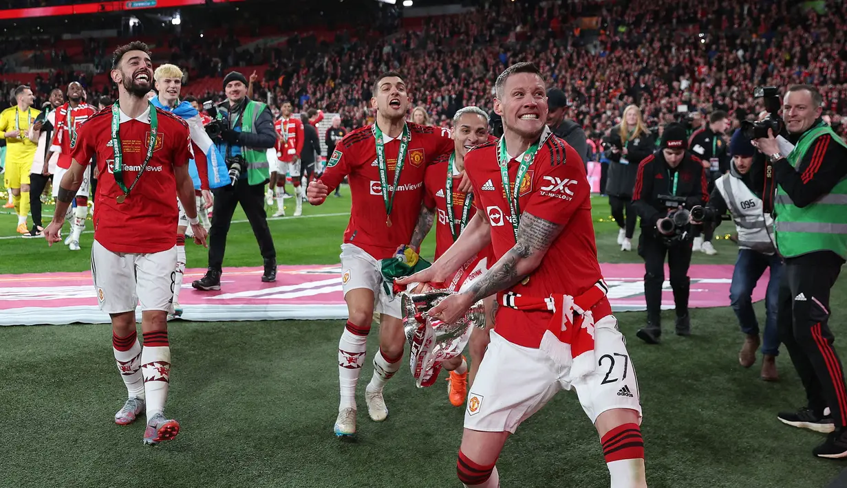 Wout Weghorst (kanan) bersama sejumlah pemain Manchester United memamerkan trofi Carabao Cup 2023 kepada suporter yang hadir di Wembley Stadium, Minggu (26/2/2023) waktu setempat. (AFP/Adrian Dennis)