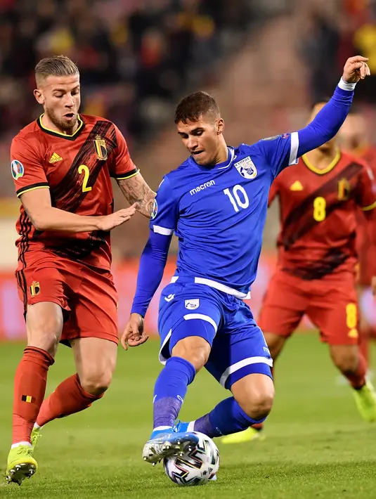 Bek Timnas Belgia, Toby Alderweireld, berebut bola dengan pemain Timnas Siprus, Pieros Sotiriou pada laga Grup I Kualifikasi Piala Eropa 2020 di Cardiff City Stadium, Selasa (19/11/2019). Timnas Belgia memetik kemenangan telak dengan skor 6-1 kala menjamu Siprus. (JOHN THYS / AFP)