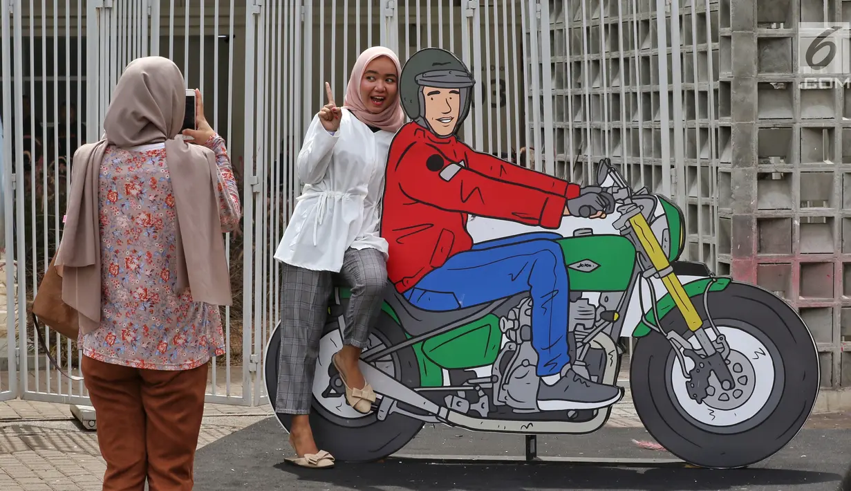 Pendukung calon Presiden no urut 01 Joko Widodo, menyempatkan foto bersama gambar karikatur Jokowi di Istora Senayan, Jakarta, Minggu (10/3). Mereka menghadiri Festival Satu Indonesia dengan penampilan topeng berwajah Jokowi. (Liputan6.com/Johan Tallo)