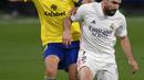 Pemain Cadiz Juan Cala (kiri) memperebutkan bola dengan pemain Real Madrid Dani Carvajal pada pertandingan La Liga Spanyol di Stadion Ramon Carranza, Cadiz, Spanyol, Rabu (21/42021). Real Madrid menang 3-0. (AP Photo/Jose Breton)