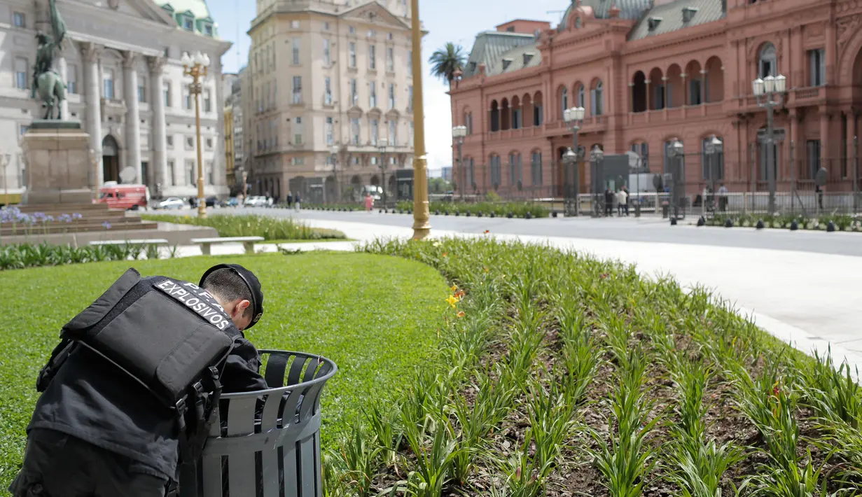Seorang perwira polisi memeriksa tempat sampah di depan Istana Kepresidenan di Buenos Aires, Argentina, Kamis (29/11). KTT G20 akan berlangsung di Buenos Aires pada 30 November-1 Desember 2018. (AP Photo/Sebastian Pani)