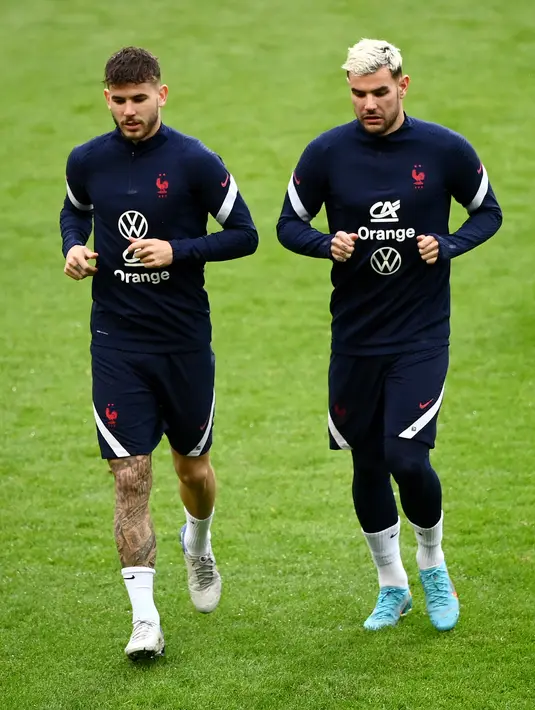 (Dari kiri) Bek Prancis Lucas Hernandez dan Theo Hernandez ambil bagian dalam sesi latihan menjelang laga persahabatan internasional, di stadion Pierre-Mauroy, dekat Lille, Senin (28/3/2022). Prancis akan beruji coba melawan Afrika Selatan pada Rabu, 30 Maret 2022 dini hari WIB. (FRANCK FIFE / AFP)