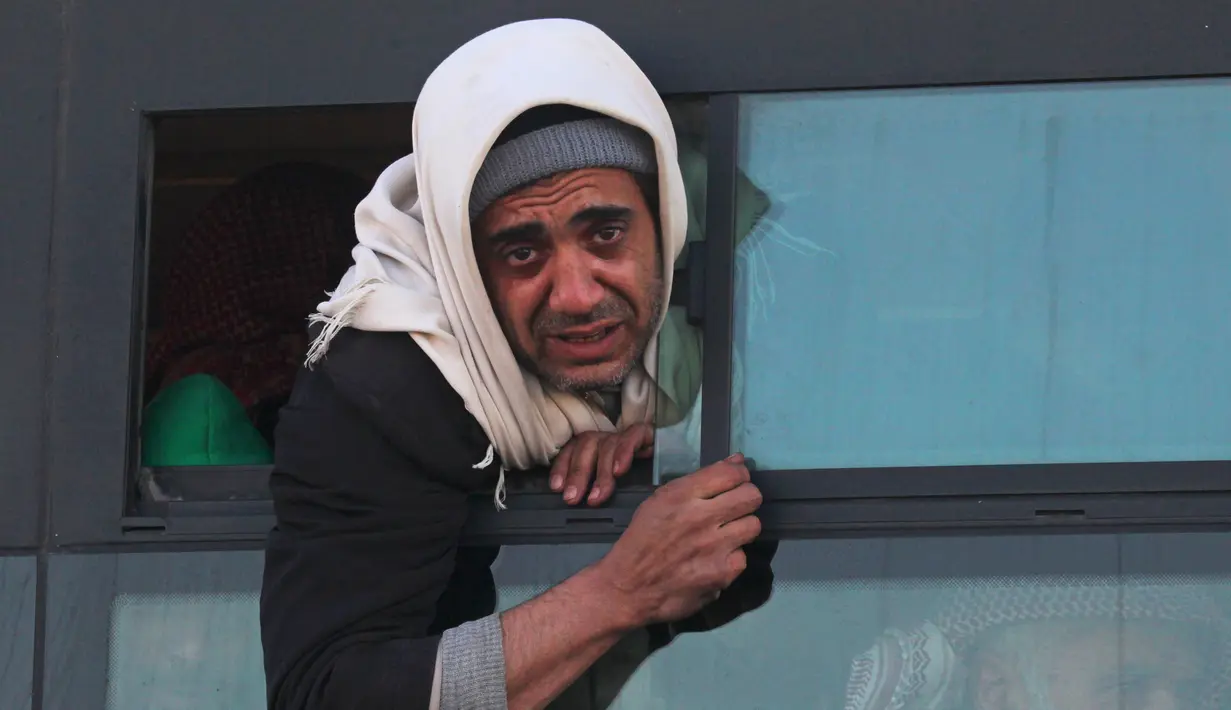 Ekspresi seorang warga saat berada di bus untuk di evakuasi di kota al-Rasyidin, Suriah (15/12). Konflik antara pemerintah dan pemberontak membuat kota Aleppo hancur. (REUTERS/Ammar Abdullah)