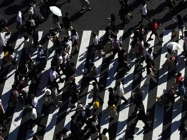 Pejalan kaki berjalan melintasi Shibuya Crossing yang juga disebut sebagai persimpangan pejalan kaki tersibuk dunia, di Tokyo, 13 Juni 2019. Di Shibuya Crossing ini juga dijadikan lokasi syuting dari film Fast & Farious: Tokyo Drift. (AP Photo/Jae C. Hong)