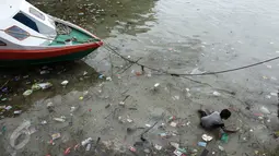 Seorang anak mencari ikan di pinggir dermaga Pulau Bunaken, Manado, yang dipenuhi sampah, Sabtu (17/12). Permasalahan sampah destinasi wisata nomor satu di Sulawesi Utara itu menjadi masalah klasik yang tak pernah terpecahkan. (Liputan6.com/Fery Pradolo)