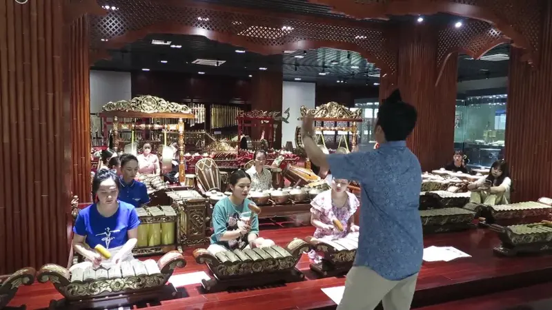 Randy Geovani Putra, seorang guru asal Indonesia, mengajarkan para siswa di China cara memainkan alat musik gamelan. (Xinhua)