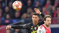 Megabintang Juventus, Cristiano Ronaldo berebut bola dengan bek Ajax Amsterdam, Daley Blind pada laga pertama perempat final Liga Champions 2018-2019 di Amsterdam Arena, Rabu (10/4). Juventus harus puas bermain imbang 1-1 di kandang Ajax Amsterdam. (EMMANUEL DUNAND / AFP)