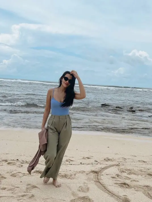 Ia juga tampil dengan spaghetti strap baby blue, dipadukan celana hijau army. Sambil mengenakan kacamata hitamnya. [@aaliya.massaid]