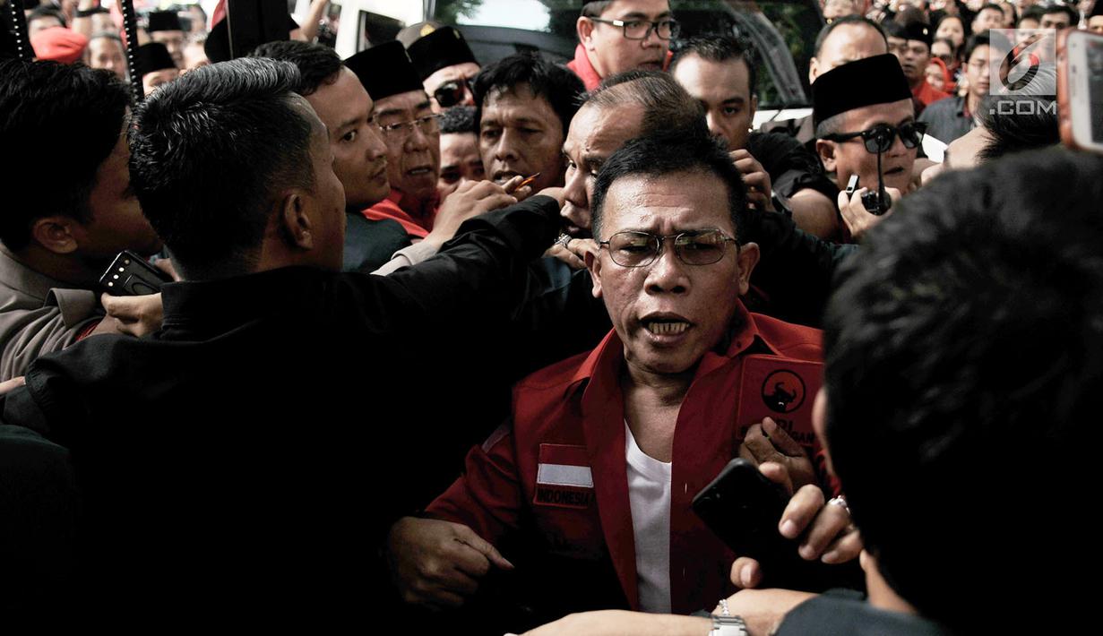 Kader PDIP Masinton Pasaribu saling dorong dengan petugas saat hendak masuk ke Gedung KPU, Jakarta, Selasa (17/7). Elite serta massa PDIP terlibat kericuhan saat hendak mengantarkan pengurus DPP mendaftarkan bakal caleg. (Merdeka.com/ Iqbal S. Nugroho)