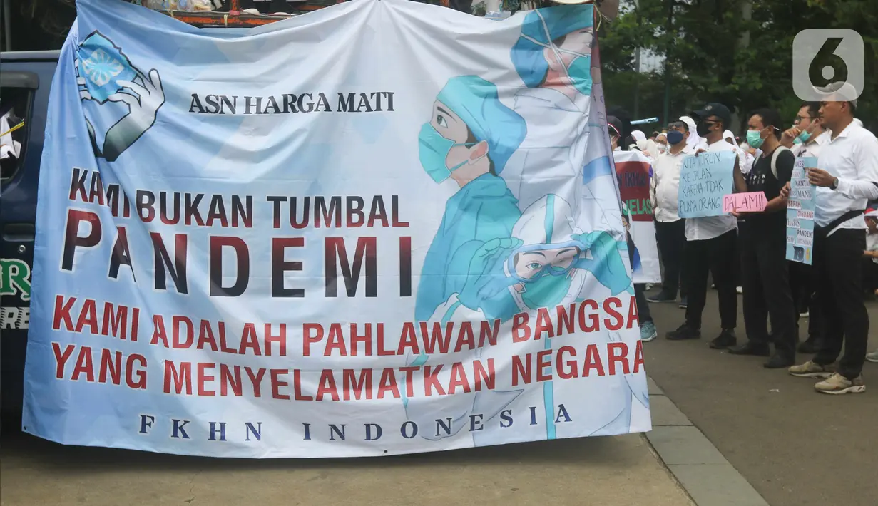 Massa dari Forum Komunikasi Nakes dan Non-Nakes Indonesia (FKHN Indonesia) membentangkan spanduk saat menggelar aksi di kawasan Patung Kuda, Jakarta Pusat, Kamis (22/9/2022). Mereka menuntut Presiden Joko Widodo (Jokowi) segera menerbitkan Peraturan Presiden (PP) khusus yang mengatur honorer nakes dan nonnakes bisa diangkat menjadi Aparatur Sipil Negara (ASN). (Liputan6.com/Herman Zakharia)