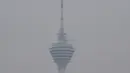 Menara Kuala Lumpur terlihat diselimuti kabut asap di Kuala Lumpur (10/9/2019). Ratusan sekolah di seluruh Asia Tenggara diliburkan menyusul memburuknya udara akibat kabut asap kebakaran hutan di wilayah itu. (AFP Photo/Mohd Rasfan)