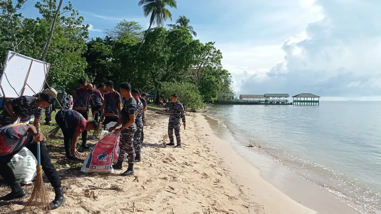 Sejumlah anggota TNI AL Kendari membersihkan sampah di pantai wisata Toronipa di Kota Kendari.(Liputan6.com/Ahmad Akbar Fua)