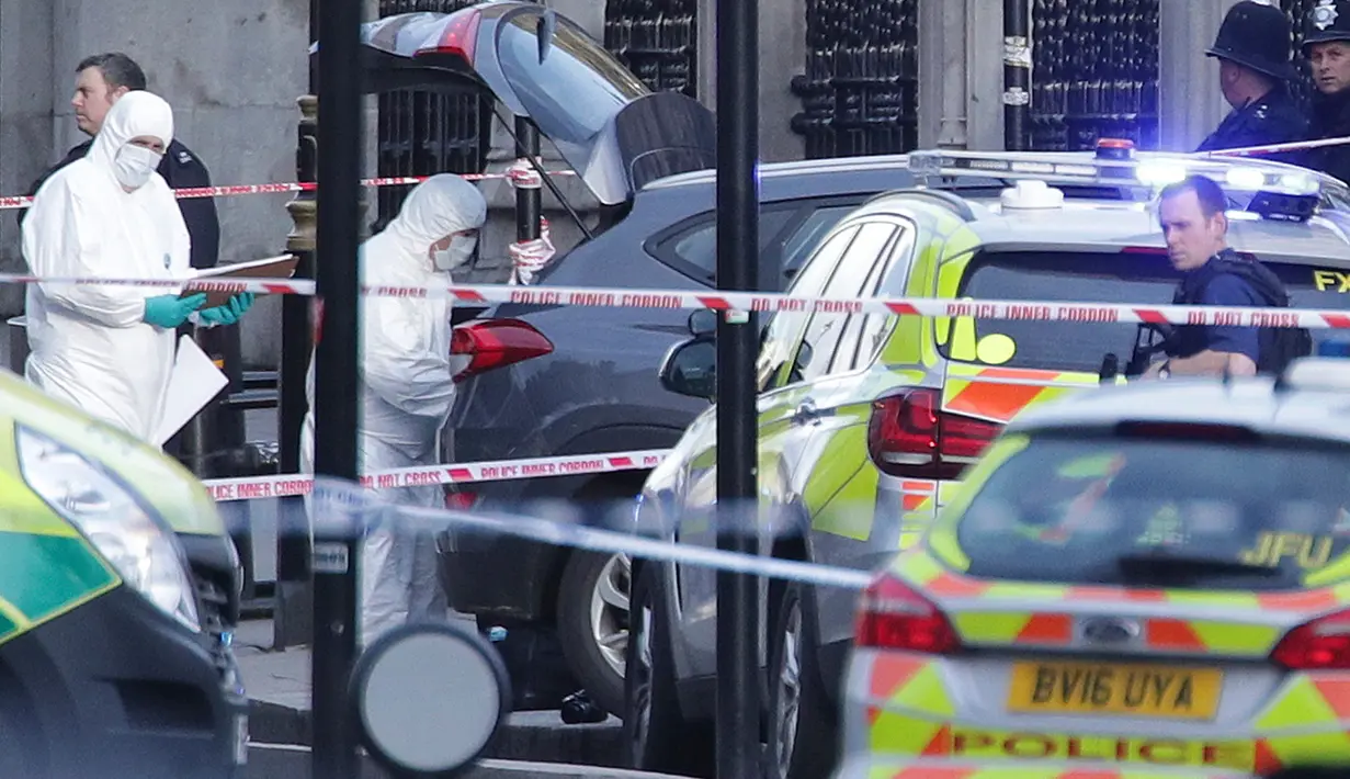 Petugas forensik meneliti lokasi serangan teror Inggris di dekat gedung parlemen di London, Rabu (22/3). Sedikitnya lima orang tewas dalam serangan teror di Jembatan Westminster dan di dekat Gedung Parlemen itu. (Yui Mok/PA via AP)