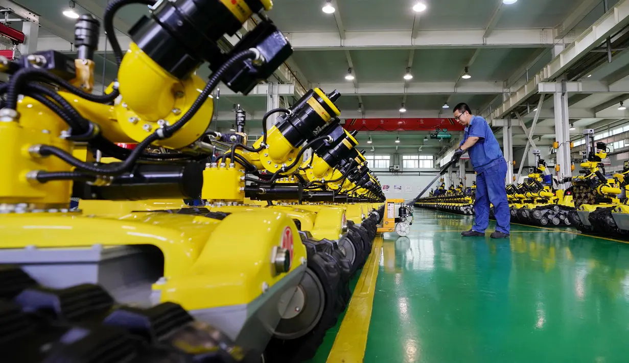 Pekerja mengangkut robot khusus di sebuah bengkel kerja di Zona Pengembangan Industri Teknologi Tinggi Tangshan, Provinsi Hebei, China (17/7/2020).  Zona Pengembangan Industri Teknologi Tinggi Tangshan telah membentuk industri robotik dengan 62 robot dan berbagai perusahaan terkait. (Xinhua/Mu Yu)