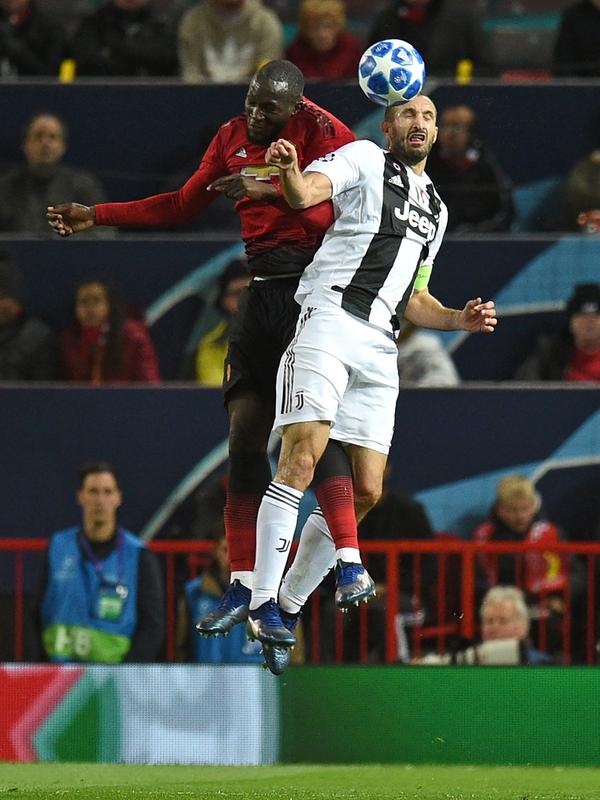 Striker Manchester United, Romelu Lukaku berebut bola udara dengan bek Juventus, Giorgio Chiellini saat bertanding pada lanjutan grup H Liga Champions di Old Trafford, Inggris (23/10). Juventus menang tipis 1-0 atas MU. (AFP Photo/Oli Scarff)