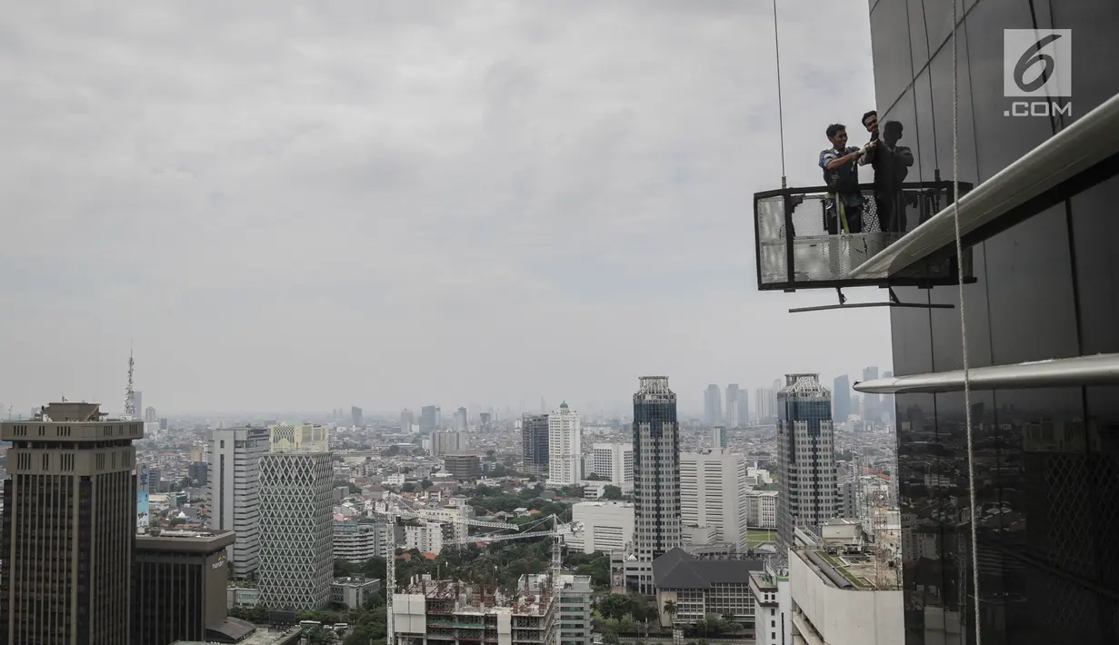 Pekerja tanpa helm keselamatan beraktivitas di gedung bertingkat di Jakarta, Rabu (15/11). Banyak kejadian kecelakaan kerja di ketinggian disebabkan karena minimnya pengetahuan dasar mengenai keselamatan kerja di ketinggian. (Liputan6.com/Faizal Fanani)
