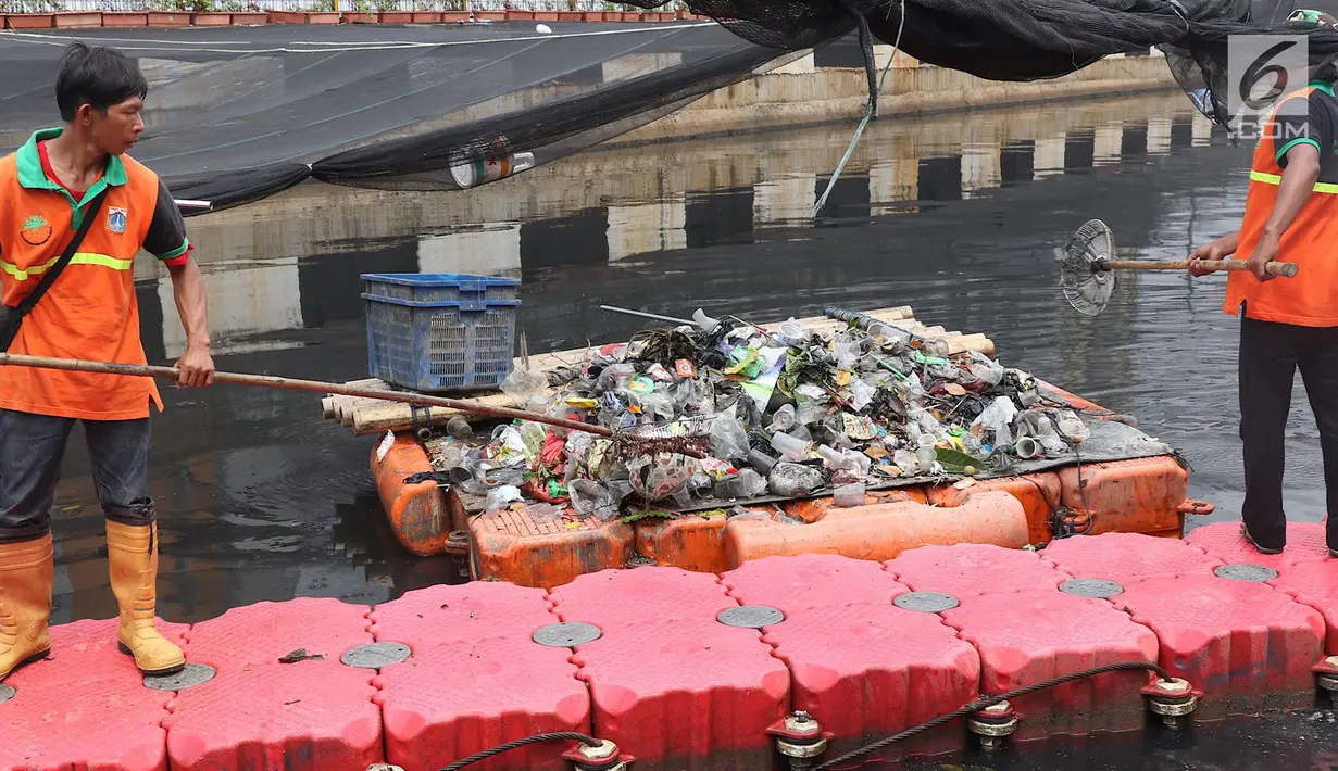 Petugas membersihkan Kali Item yang tertutup kain waring atau jaring di Kemayoran, Jakarta, Minggu (4/11). Sampah plastik, botol mineral, kaleng dan bungkus rokok bertebaran di waring yang membentang di atas Kali Item. (Liputan6.com/Immanuel Antonius)