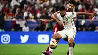Striker Timnas Yordania, Ali Olwan dijaga dengan ketat oleh bek Timnas Qatar, Tarek Salman dalam laga final Piala Asia 2023, Sabtu (10/2/2024) malam WIB di Lusail Stadium, Qatar. (AFP/Jawel Samad)
