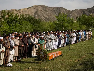 Teman dan kerabat mensalatkan jenazah kepala fotografer Agence France Presse (AFP) Afghanistan Shah Marai Faizi di Gul Dara, Kabul (30/4). (Andrew Quilty / POOL / AFP)