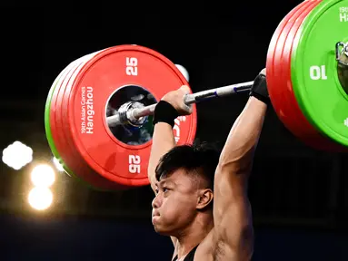 Lifter Indonesia, Rahmat Erwin Abdullah  berkompetisi dalam kompetisi angkat besi grup A 73kg putra Asian Games 2023 di Hangzhou, China, 3 Oktober 2023. (Ishara S.KODIKARA / AFP)