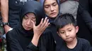 Dengan mengenakan pakaian hitam, serta hijab warna senada, beberapa kali istri Muhammad Fachroni alias Oon mengusap air matanya yang mulai membasahi pipinya. (Deki Prayoga/Bintang.com)