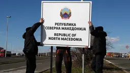 Pekerja memasang papan nama negara baru Republik Makedonia Utara di perbatasan Makedonia-Yunani, dekat Gevgelija, Rabu (13/2). Nama baru negara tersebut mulai berlaku pada 12 Februari melalui perubahan konstitusi yang diterbitkan. (AP/Boris Grdanoski)
