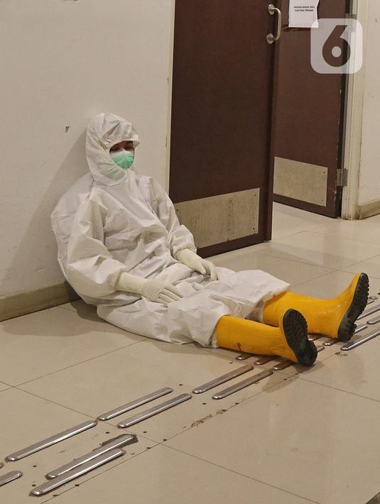 Seorang tenaga kesehatan beristirahat disela aktivitasnya di RSDC Wisma Atlet, Jakarta, Selasa (26/1/2021). Data Satgas Covid-19 per Selasa (26/1) mencatat kasus COVID-19 di Indonesia bertambah 13.094 sehingga total menyentuh angka satu juta, tepatnya 1.012.350. (Liputan6.com/Herman Zakharia)