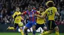 Striker Crystal Palace, Jordan Ayew, berusaha melewati bek Arsenal, Sokratis Papastathopoulos, pada laga Premier League di Stadion Selhurst Park, London, Sabtu (11/1). Kedua klub bermain imbang 1-1. (AFP/Daniel Leal-Olivas)